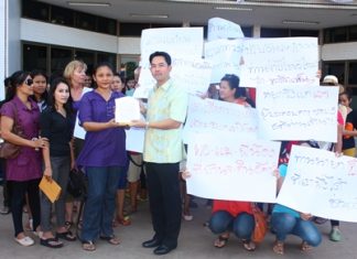Jomtien Soi 5 merchants protests construction, fines Mayor Itthiphol Kunplome (center) accepts a document outlining their complaint from protest leader Pranee Klawit.