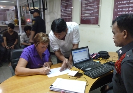 Russian victim Nina Vitiutneva fills out a police report after being robbed on the ocean side of Pratamnak Hill.