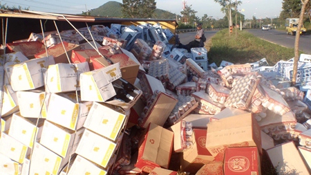 Party delayed - Yongyuth Srimawong escaped serious injury when his beer truck overturned, but the same can’t be said for his amber cargo. 