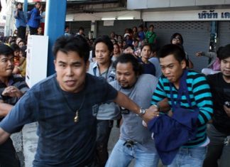 Initially defiant when arriving at the scene, confessed murderer Thiwanont Bunruang (striped shirt, right) had to run for his life when the crowd turned on him, despite undercover cops doing their best to protect him.