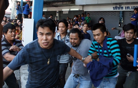 Initially defiant when arriving at the scene, confessed murderer Thiwanont Bunruang (striped shirt, right) had to run for his life when the crowd turned on him, despite undercover cops doing their best to protect him.