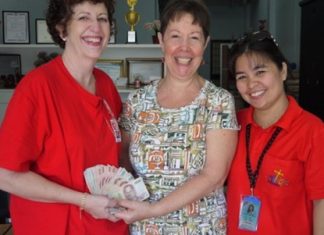 Judith hands the generously donated money to Francesca and Leng Leng at the Mercy Centre.