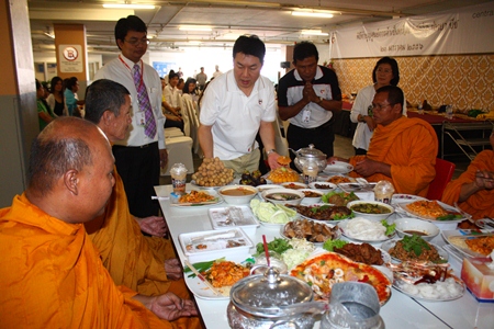 General Manager Saran Tantijamnaj (center) serves lunch to the monks during Central’s anniversary merit making.