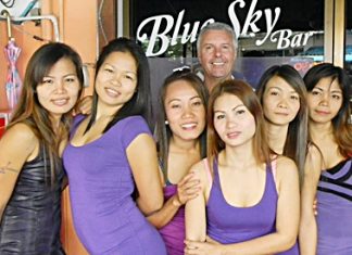 Mike ‘Michelle’ Chatt (center rear) poses with the staff at Blue Sky Bar.