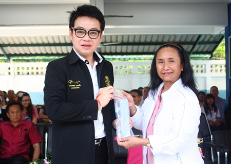 Bunlai Vankhula (right), from the Thammasart Association of California, presents a slate and stylus to Pattaya councilman Rattanachai Suthidechanai to distribute to the children for learning how to write Braille.
