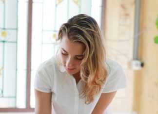 A GIS student helps a younger student with a drawing task.