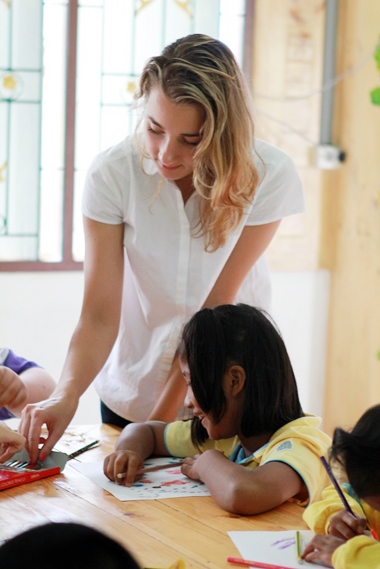 A GIS student helps a younger student with a drawing task.
