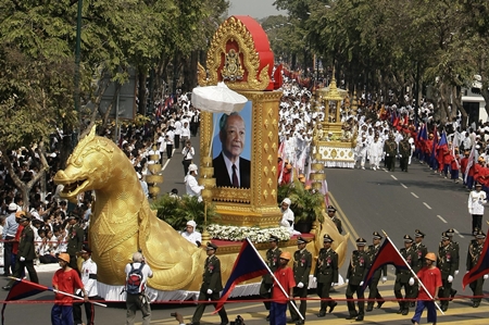 The chariot carrying the portrait of late former King Norodom Sihanouk leads his royal funeral procession Friday, Feb. 1, 2013, in Phnom Penh, Cambodia. Thousands of mourners accompanied a gilded chariot carrying the body of former King Sihanouk - the dominant figure of modern Cambodia - in a funeral procession Friday to a cremation ground next to the palace where he was crowned more than 70 years ago. (AP Photo/Heng Sinith)