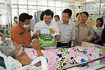 Deputy Public Health Minister Cholnan Srikaew wraps up his visit by presenting gifts to hospitalized patients.
