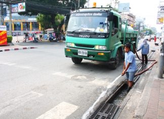 City workers clean out the drains along Second Road in North Pattaya.