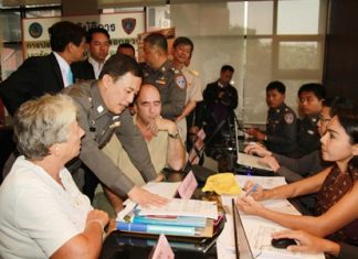 Royal Thai Police advisor Lt. Col. Wuthi Liptapanlop leans in to talk with foreign guests at the new consumer protection office inside city hall.