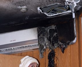 A firefighter inspects the offending air-conditioner that caught fire inside Pavilion Massage on Second Road.
