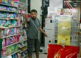 Yuri Gubenko, allegedly upset over the loss of his girlfriend, threatens police with a pair of knives inside an East Pattaya 7-Eleven.