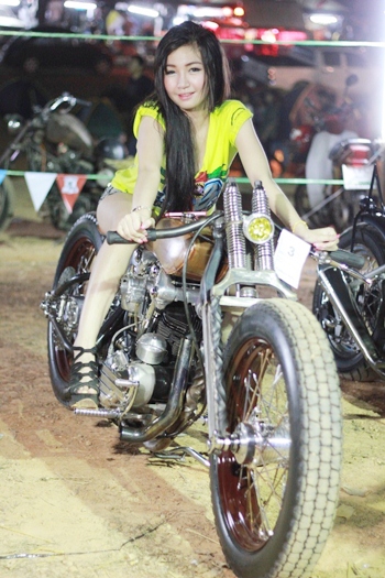 A beautiful model poses on a retro bike.