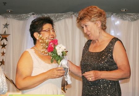 Founding member Somthavin “Tiew” Suphamongkon (left) receives flowers from Ann Winfield.