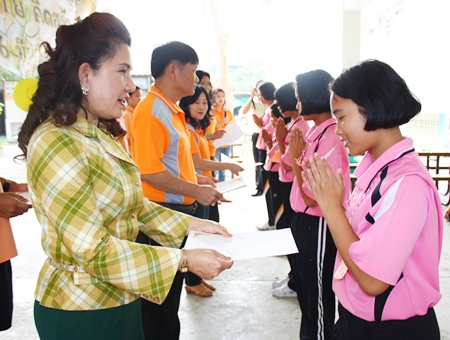 Sunisa Sombun (left), assistant director of Photisampan Pittayakarn School, presents certificates to children who participated in the science camp.