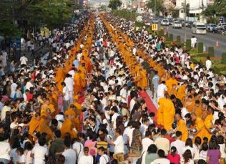 The southbound lane on Sukhumvit Road in Rayong was turned into a sea of orange and white as residents presented alms to 2600 monks to celebrate Jayanti.