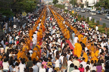 The southbound lane on Sukhumvit Road in Rayong was turned into a sea of orange and white as residents presented alms to 2600 monks to celebrate Jayanti.