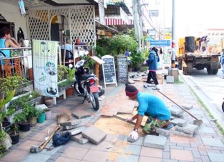 Workers first had to fill in the hole and level the sand before placing in the new tiles.