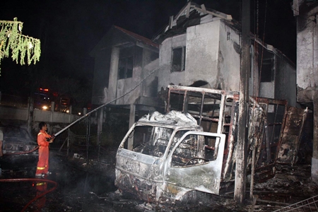 Firefighters put out a blaze at an illegal benzene storage depot that exploded, destroying three homes.