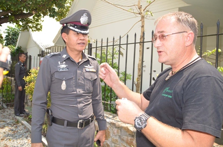 With a backdrop of bullet holes in his neighbor’s house, Bryan Anderson (right) tells police what he heard.