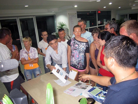 Russian tourists file a complaint with Pattaya Police Superintendent Suwan Chiewnawinthawat (striped shirt, leaning over table with paper in hand) against World of Chang Co. for fraud.