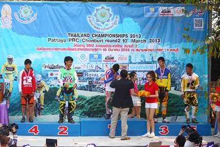 Lt. Gen. Phadungsak Klansanoh, vice president of Thai Cyclist Association under the royal patronage, presents medals to winning cyclists in the U 14 female category.
