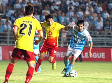 Pattaya United’s Anuwat Inyin (right) dribbles past Osotspa defenders during the second half of the Thai Premier League match at the Nongprue Stadium, Sunday, March 10.