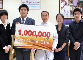 Father Peter accepts the cheque from the Bangkok students.