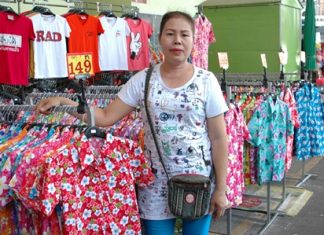Somjit Sodkhomkhum, a clothing saleswoman serving New Naklua Market vendors, poses with some of her stock.