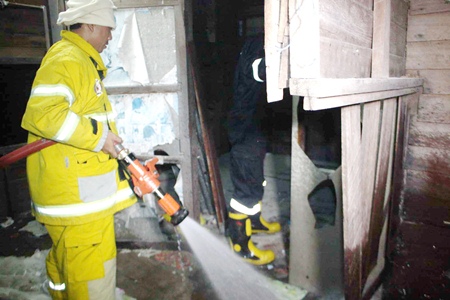 Firefighters move in to extinguish the final embers after smoking in bed caused a fire that destroyed a house in Sattahip.