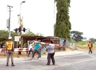 City workers repair the train-crossing gate damaged by a speeding car on Soi Siam Country Club.