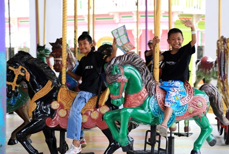 Youngsters enjoy riding the horses on the merry-go-round.