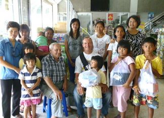 Woody and Bernie (seated center) say that outfitting these children for school is something the Jesters Care for Kids are happy to do.