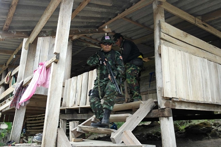 Armed law enforcement officials raid a suspected illegal rubber plantation on the outskirts of Rayong.