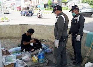 Municipal police officers question this person, and finding him to be homeless, transfer him to a shelter.