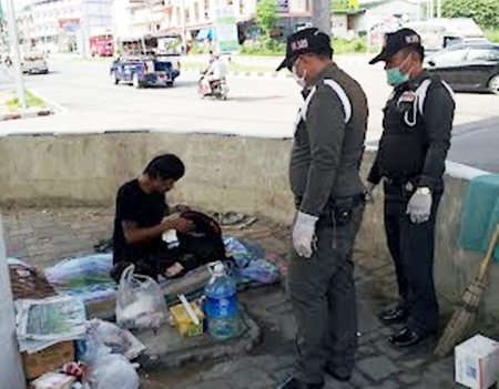 Municipal police officers question this person, and finding him to be homeless, transfer him to a shelter.