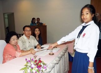 Mrs. Wanthanee Supornsahatrangsi (left), assistant MD of Sunshine hotels and resorts, presents 2,000 baht scholarships to children in Prathom 1-6.