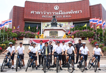 Deputy Mayor Ronakit Ekasingh (center left), and Pol. Lt. Col. Arun Promphan (center right) pose for a group photo with patrol officers and municipal officers after the new bicycle handover.