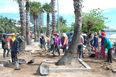 Laborers, some shown here improving the diminishing beach landscape for the May Day celebration, say 300 baht a day is still not enough for them to make ends meet in today’s ever changing economy.