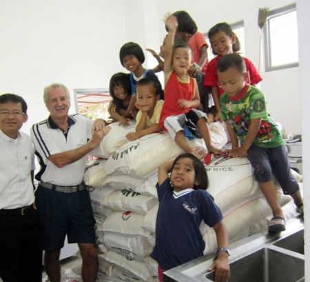 Children of the Camillian Centre climb to the top of the rice pile.