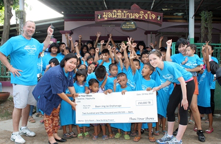 Lisa Koenig (front, right) presents 250,000 baht raised through her “Thai Your Shoes” organization to Ban Jing Jai.