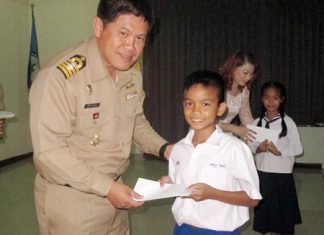 Royal Thai Navy’s 2nd Anti-Aircraft Artillery Regiment commander, Capt. Wirat Somjit presents one of the 2,000 stipends to a grateful student.