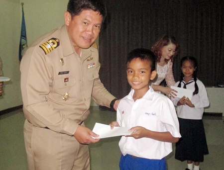 Royal Thai Navy’s 2nd Anti-Aircraft Artillery Regiment commander, Capt. Wirat Somjit presents one of the 2,000 stipends to a grateful student.