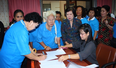 Members of Pattaya’s Elderly Club sign up for a city-organized meditation and merit-making trip to Issan.