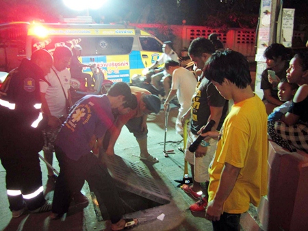 Rescuers use a crowbar to lift the lid off the 80cm pipe.