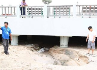 Pattaya Deputy Mayor Verawat Khakhay and Sanitation Department Director Wirat Jeerasriphathun inspect the sand buildup under the Naklua flood runoff canal.