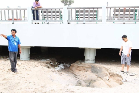 Pattaya Deputy Mayor Verawat Khakhay and Sanitation Department Director Wirat Jeerasriphathun inspect the sand buildup under the Naklua flood runoff canal.