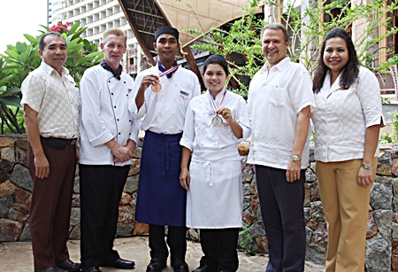 Andre Brulhart (2nd right), Area General Manager of Centara Grand Mirage Beach Resort Pattaya, congratulates Prawit Sangkheet (3rd left) and Jamnong Sessathit (3rd right), two of the resort’s kitchen staff who earned two awards at the Thailand Ultimate Chef Challenge 2013 (THAIFEX - World Food Asia) held at IMPACT Muang Thong Thani recently. Prawit won a bronze medal at the Modern Thai cuisine competition, and Jamnong a silver medal from the contest for four different Individual Western Plated Desserts. Also seen congratulating the two winners are Wuthisak Pichayagan (left), Executive Assistant Manager for Food and Beverage, Executive Chef Colin Grant (2nd left), and Daranat Nuchaikaew (right), Director of Human Resources.
