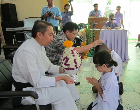 Students from nursery present flowers, candles, and incense to Father Pattarapong Srivorakul, president of Father Ray’s foundation (left), and Chonburi Primary Education Region 3 Deputy Director Supamit Sirakantamakul.